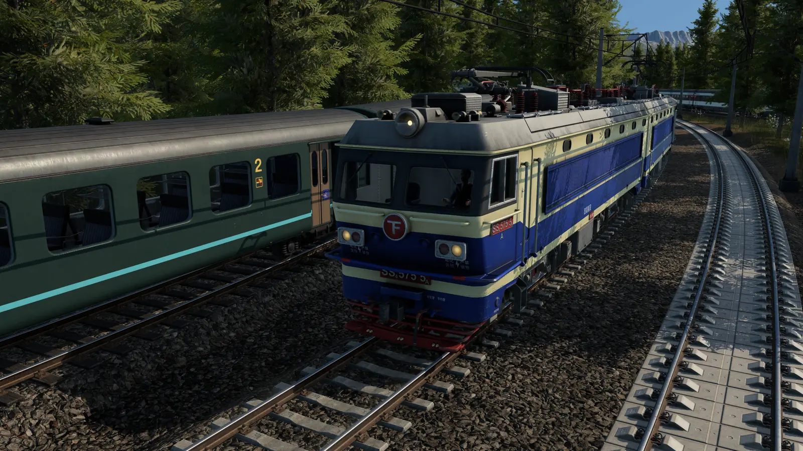 A blue electric locomotive passing a green passenger coach on parallel tracks in Transport Fever 3, with a third track curving away under overhead wires