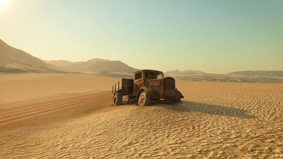 A rusty old truck alone on the sand of a desert valley in Transport Fever 3, from the campaign's third mission