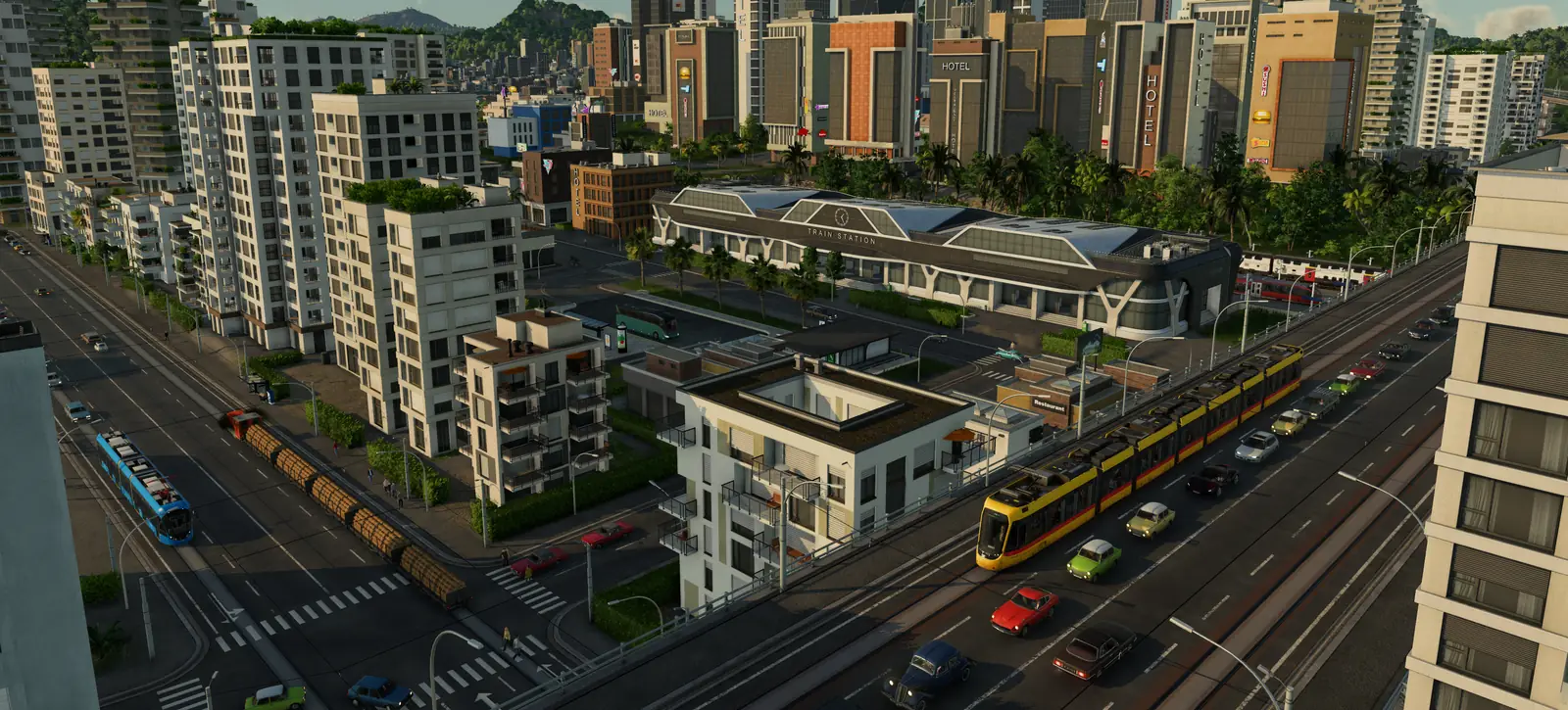 A busy Transport Fever 3 city with high-rise hotels behind a train station, a yellow tram and cars on the main road, a blue tram and a train loaded with logs